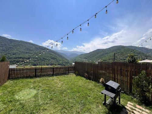 a backyard with a fence and a grill and mountains at Motives Inn Dilijan in Dilijan