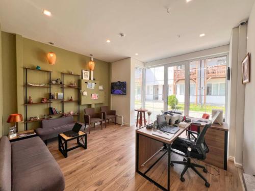 a living room with a couch and a desk in a room at Motives Inn Dilijan in Dilijan