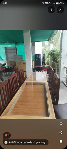 a large wooden table in a room with chairs at Turtuk in Turtuk