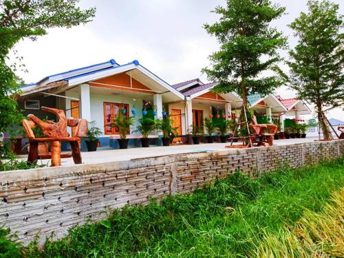 a house with a brick wall and chairs in front of it at Kiangna resort Chiang Rai in Ban Pa O (1)