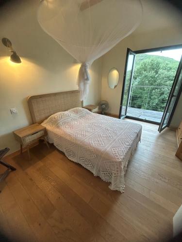 a bedroom with a bed and a large window at Sisco Nature in Sisco