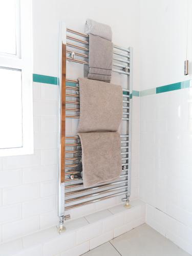 a towel rack with towels on it in a bathroom at Modern 6 Person Cosy Cottage in Historical Newport in Caerleon