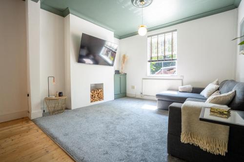 a living room with a couch and a fireplace at Modern 6 Person Cosy Cottage in Historical Newport in Caerleon