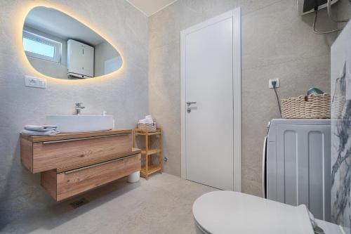a bathroom with a sink and a mirror at Mićos Beach Studio with Pool in Slatine