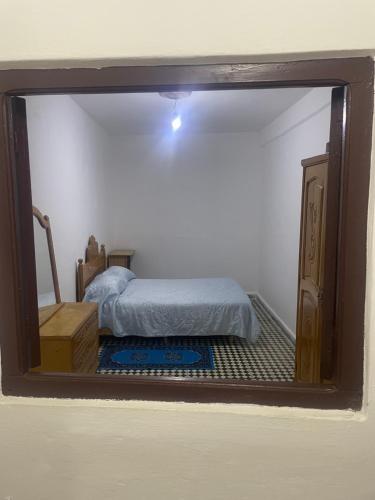 Un reflejo en el espejo de una cama en un dormitorio. en Catalan, en Martil