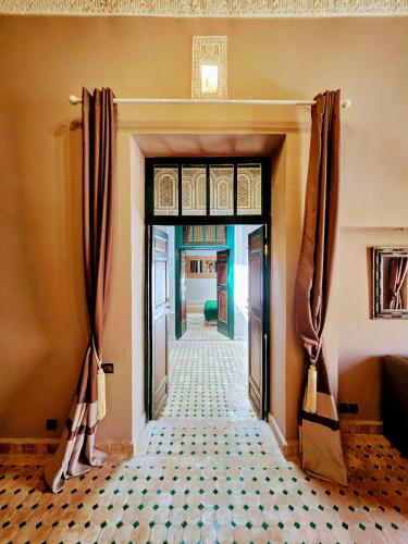 a hallway with a door with curtains and a tile floor at Riad Kasbah privilège and SPA in Marrakech