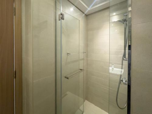 a shower with a glass door in a bathroom at Luxe Studio Vibes Stylish & All New Pet Free in Dubai