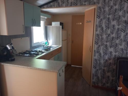 a kitchen with a stove and a refrigerator at Mobil Home La Belle Vie in Vaudreuille