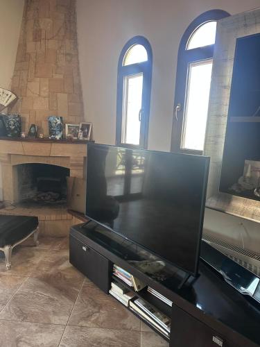a living room with a large flat screen tv at Marsia House in Vathí