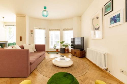 a living room with a couch and a tv at Mews House South Ken in London