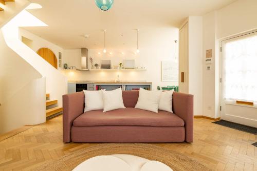 a couch in a living room with a kitchen at Mews House South Ken in London