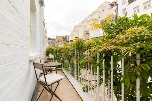 a balcony with a table and chairs and plants at Mews House South Ken in London