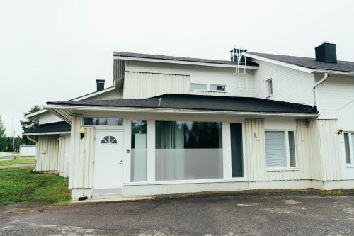 a white house with a white door at Ranua Keskustie Polar Apartment in Ranua