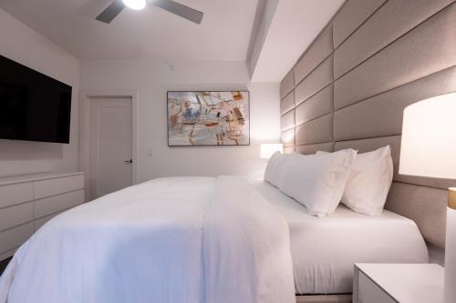 a white bedroom with a large bed and a tv at Cozy Apartment in Atlanta in Atlanta