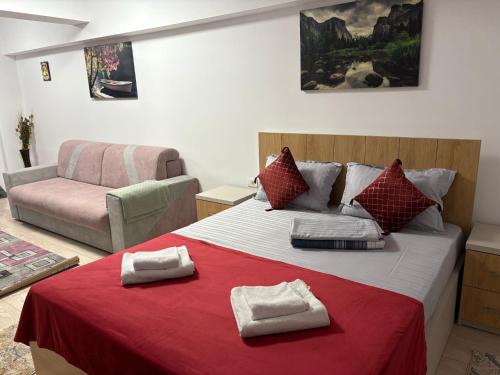 a bedroom with a large bed and a couch at Studio Lavinia in Eforie Nord