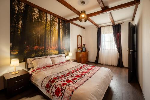 a bedroom with a large bed with a painting on the wall at La Mosie-Ruda in Ruda