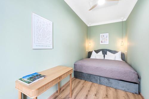 a small bedroom with a bed and a desk at Mamalipa Apartments in Vienna