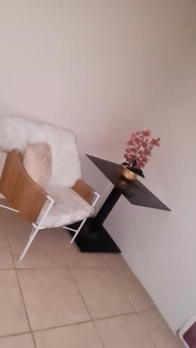 a table with a chair and a vase of flowers on it at Penthouse villa in Montego Bay