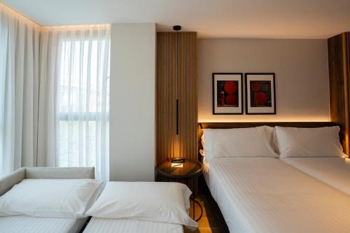 a bedroom with two beds and a window at Zenit Borrell in Barcelona