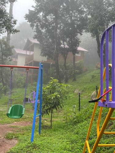 a playground in the rain with swings at Coorg Jungle Mist in Madikeri