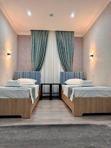 a room with two beds and a window at Mehran in Andizhan