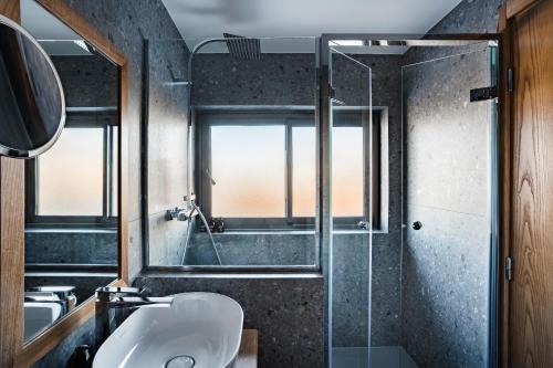 a bathroom with a sink and a glass shower at Hotel Annapurna in Courchevel