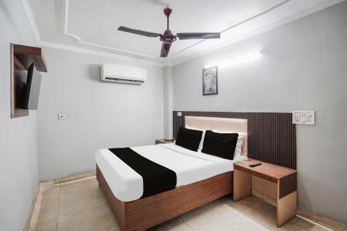 a bedroom with a bed and a ceiling fan at Hotel O by OYO Exotica Palace in New Delhi