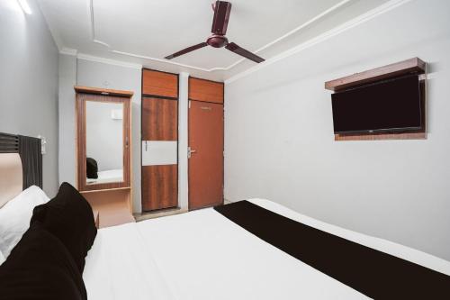 a bedroom with a bed and a flat screen tv at Hotel O by OYO Exotica Palace in New Delhi