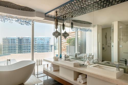 a bathroom with two sinks and a tub and a large window at Marriott Marquis Dubai Creek in Dubai