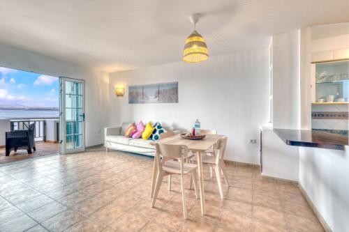 a kitchen and living room with a table and chairs at Apartamento El Charcon A - 10 meters to the Beach By Lanzarote Vacation Homes in Arrieta
