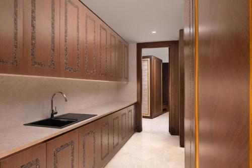 a kitchen with a sink and wooden cabinets at Marriott Marquis Dubai Creek in Dubai