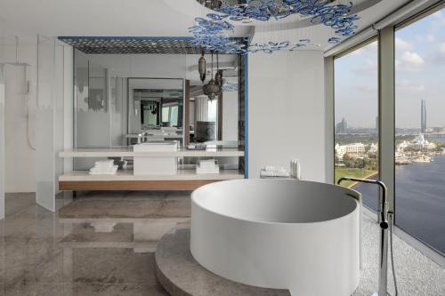 a bathroom with a white tub and a large window at Marriott Marquis Dubai Creek in Dubai