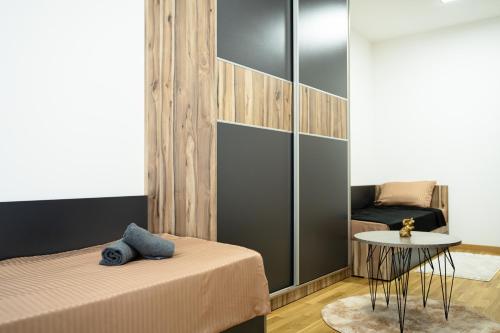 a bedroom with a bed and a table and a chair at Comfort Apartment Skopje in Skopje