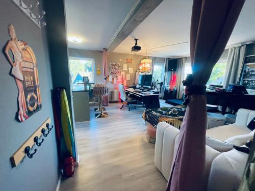 a room with a living room with a desk and a room with a room at Exklusives Heidehaus in Garlstorf mit Musikzimmer in Garlstorf