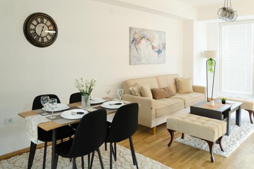 a living room with a table and a couch at Comfort Apartment Skopje in Skopje