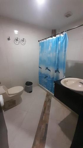 a bathroom with a toilet and a shower curtain at Sunset Taganga Hotel in Taganga