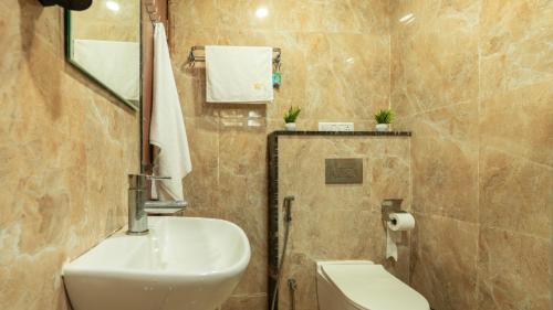 a bathroom with a sink and a toilet at SaffronStays Nivasa Whitefield, Bangalore in Bengaluru
