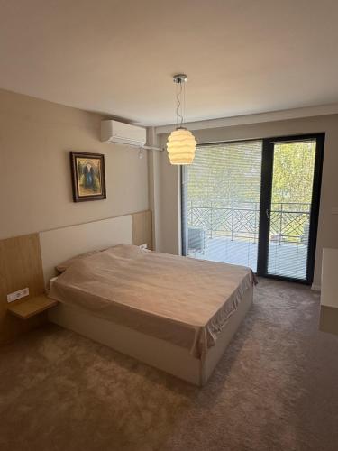 ein Schlafzimmer mit einem Bett und einem großen Fenster in der Unterkunft RIVERSIDE Kozloduy in Kozloduy