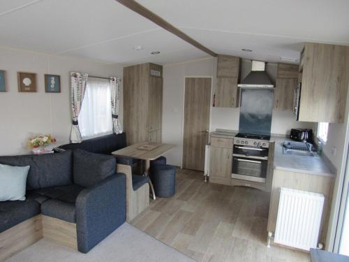 a living room with a couch and a kitchen at Caravan at Family Park WiFi, Parking in Dawlish Warren
