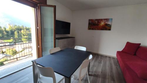 a living room with a table and a red couch at The View 1 in Teglio