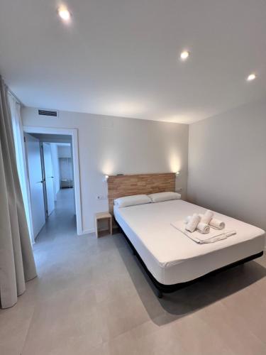 a bedroom with a white bed with two towels on it at Camping Joncar Mar in Roses
