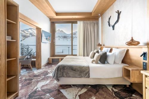 a bedroom with a bed and a large window at Hotel Annapurna in Courchevel