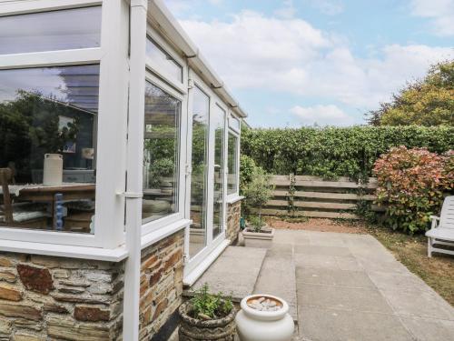 a house with a window and a patio at Thurlestone, 1 Island View in Kingsbridge
