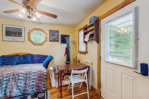 Sugarbush VillageにあるTiny House at Mt Ellenのベッドとテーブルと窓のある寝室