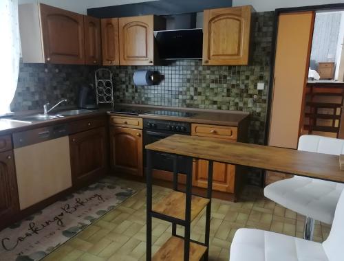 a kitchen with wooden cabinets and a wooden table at Küstenglück in Wilhelmshaven