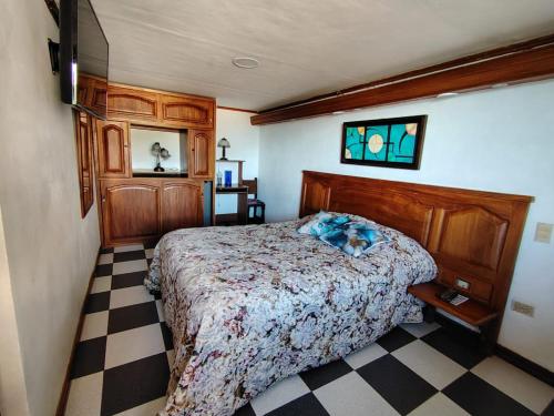 a bedroom with a bed and a checkered floor at Hotel Posada La Porra in Concordia