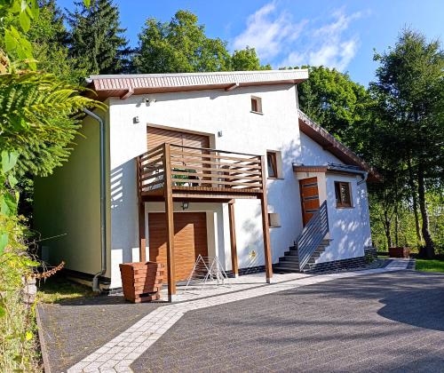 斯克拉斯卡波伦巴Furtka do Lasu的白色的小房子设有阳台和楼梯