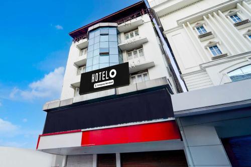 a hotel sign on the side of a building at Hotel O Market Road Ernakulam in Cochin