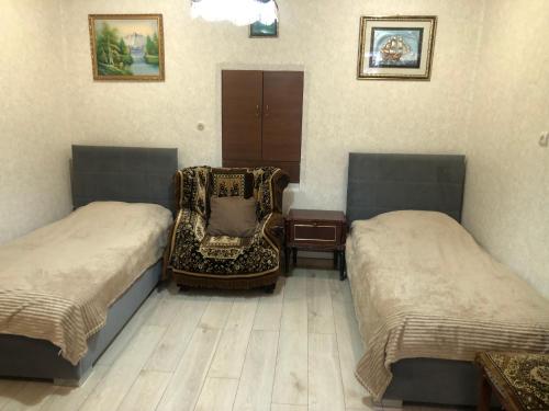 a room with two beds and a chair in it at Sweet house 1 in Gyumri