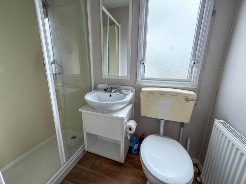 ein kleines Badezimmer mit Toilette und Waschbecken in der Unterkunft Lovely 6 Berth Caravan At St Osyth Beach Holiday Park In Essex Ref 28035Fi in Clacton-on-Sea